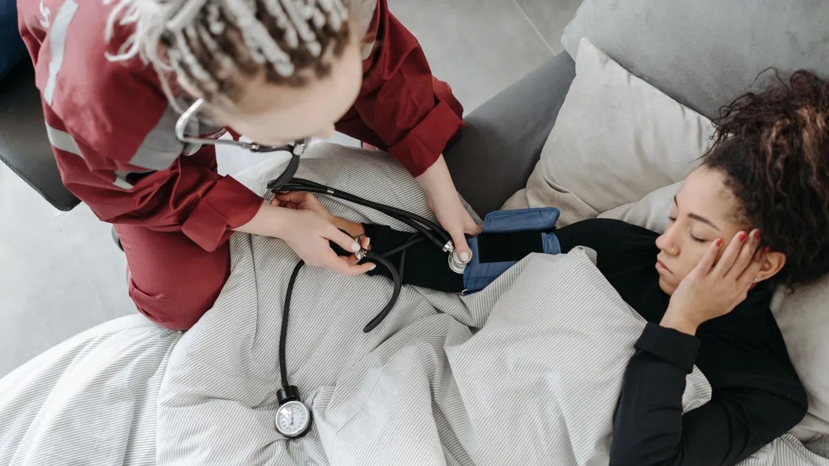 Overhead view of nurse checking a patient in bed