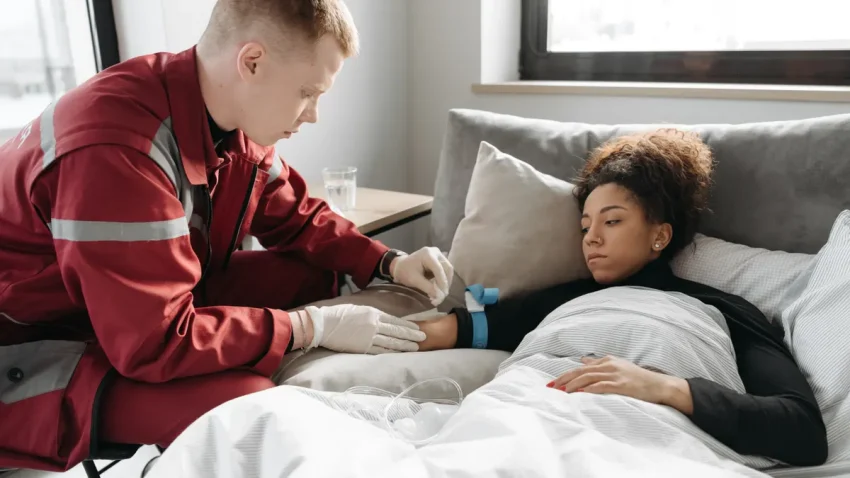 Home nurse checking a patient in bed